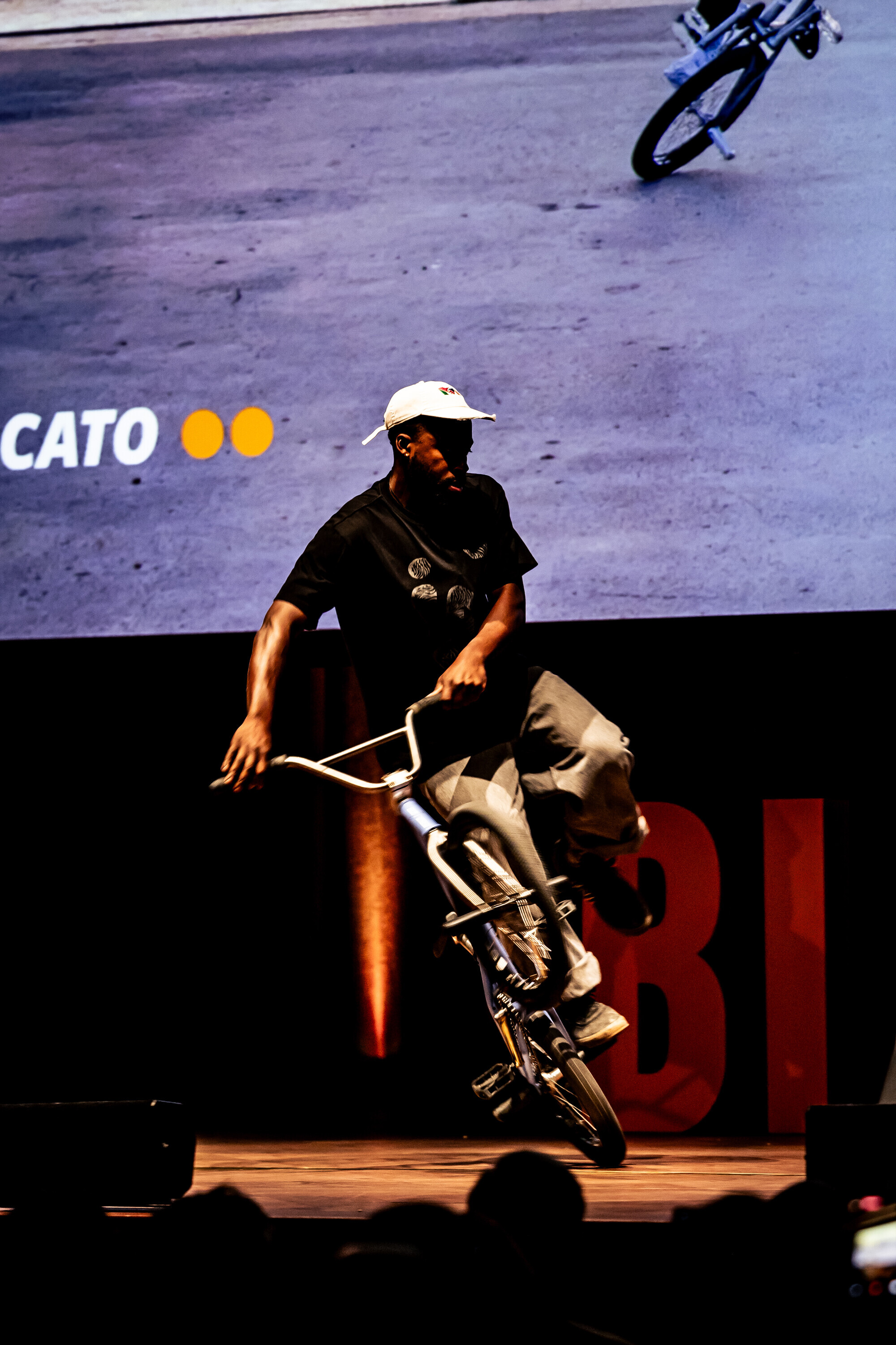 Omari Cato f&uuml;hrt w&auml;hrend einer Veranstaltung der Bike Film Tour auf der B&uuml;hne einen Flatland-BMX-Trick vor.