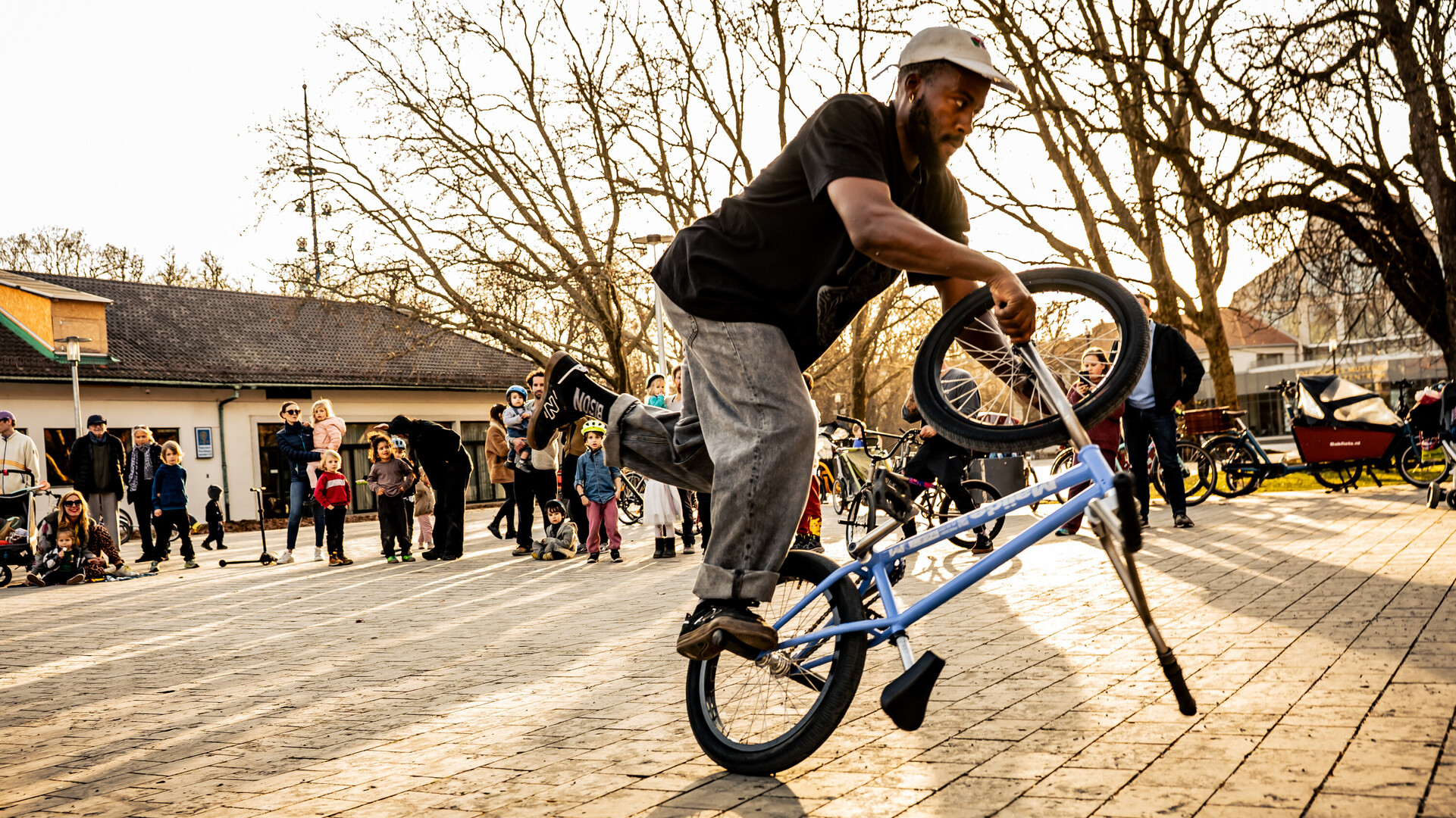 Omari Cato f&uuml;hrt auf einem Stadtplatz vor Zuschauern einen Flatland-BMX-Trick vor.