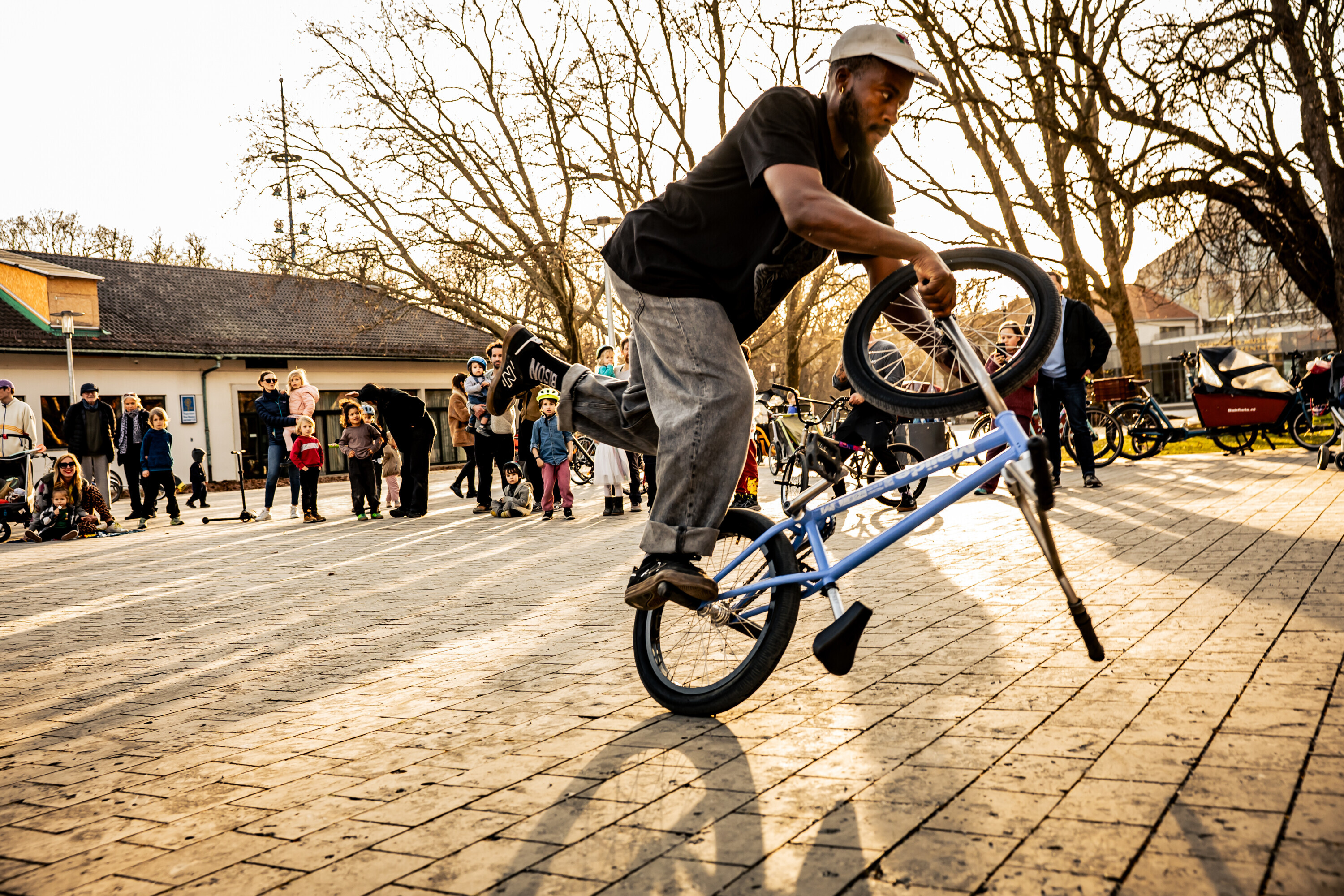 Omari Cato f&uuml;hrt auf einem Stadtplatz vor Zuschauern einen Flatland-BMX-Trick vor.