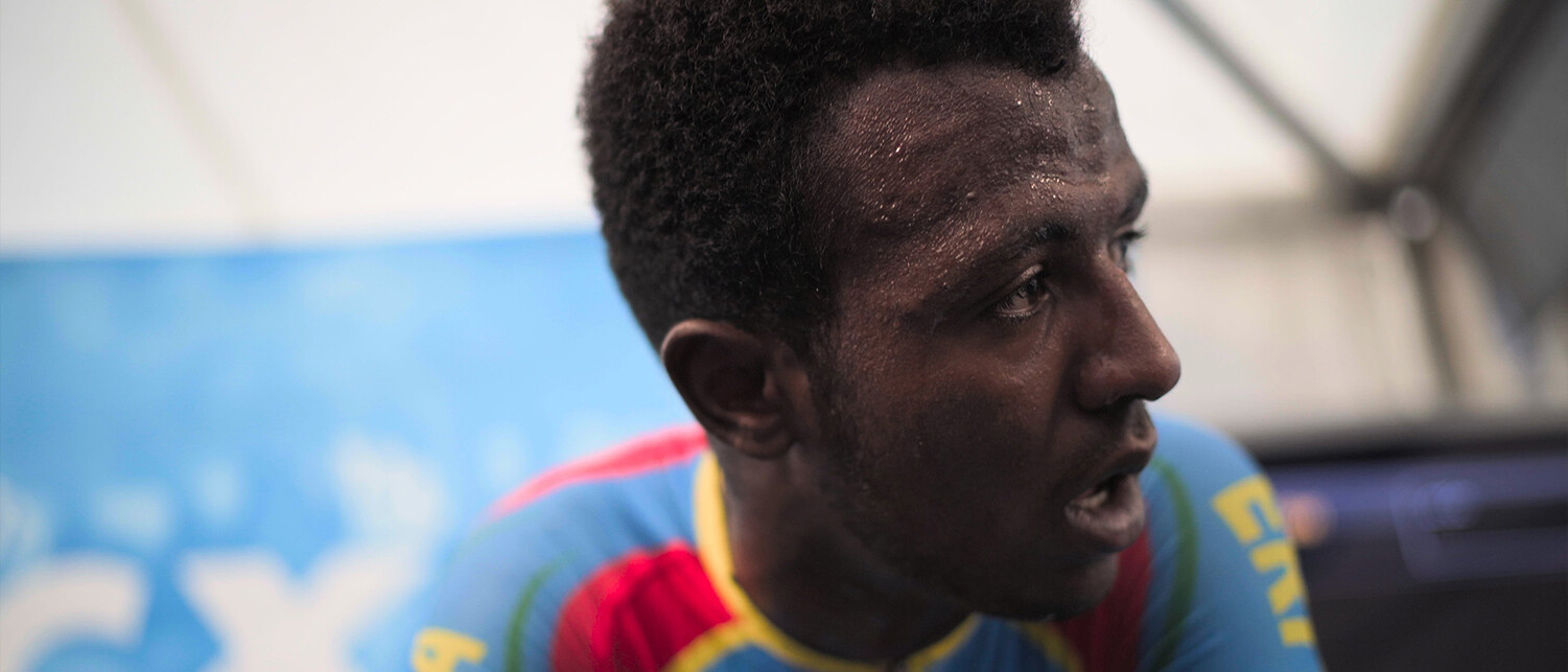 Close-up of cyclist Biniam Girmay, sweating and looking focused after a race.